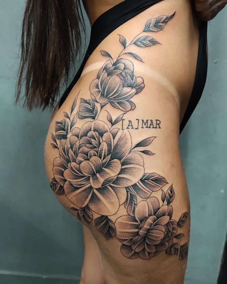 Tatuagem floral com escrita [A]MAR no quadril