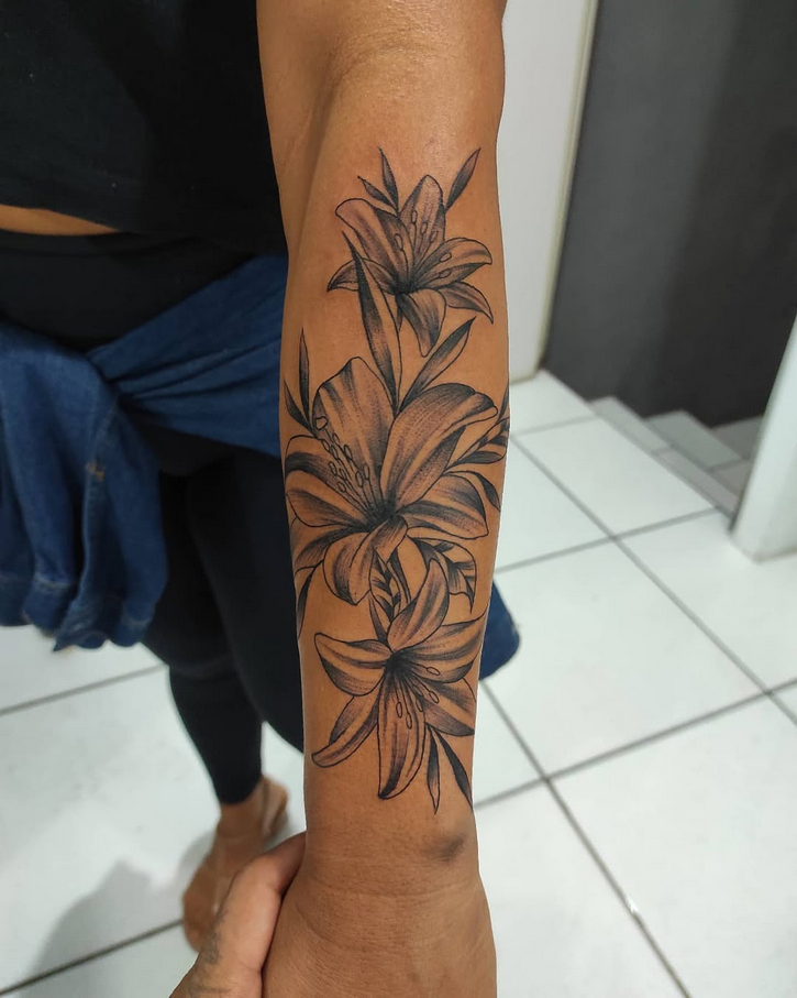 Tatuagem delicada de lírios no antebraço